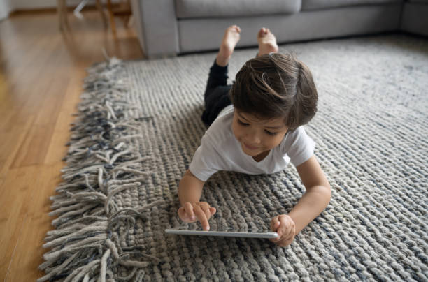 Girl with tablet laying on floor | Messina's Flooring